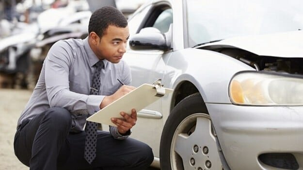 Claims Adjuster inspecting damaged car in Asheville, NC