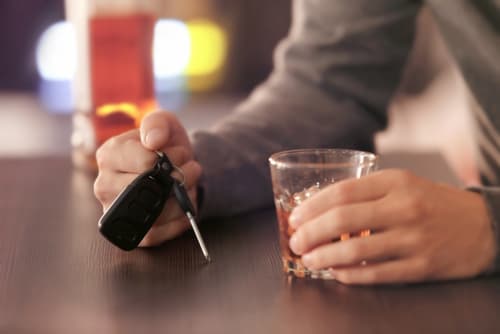 person drinking and holding car keys